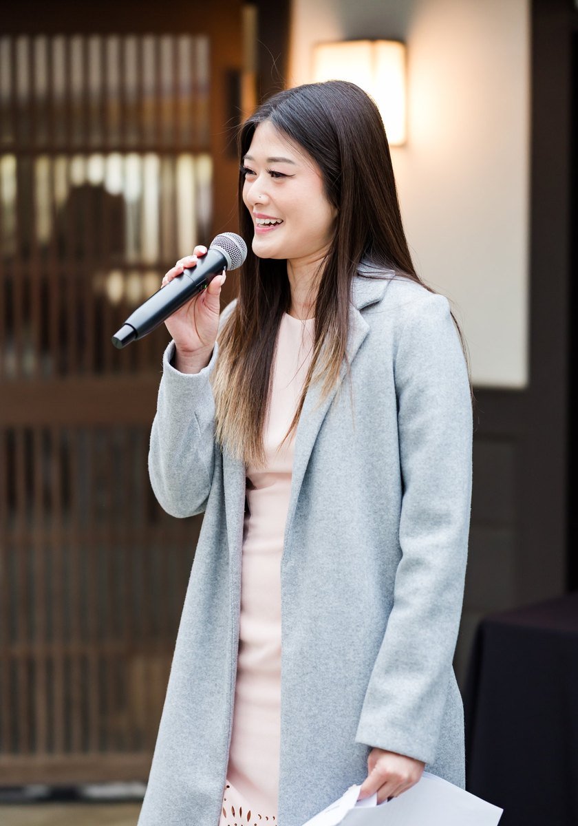 Lisa Nguyen speaking on the microphone as wedding MC