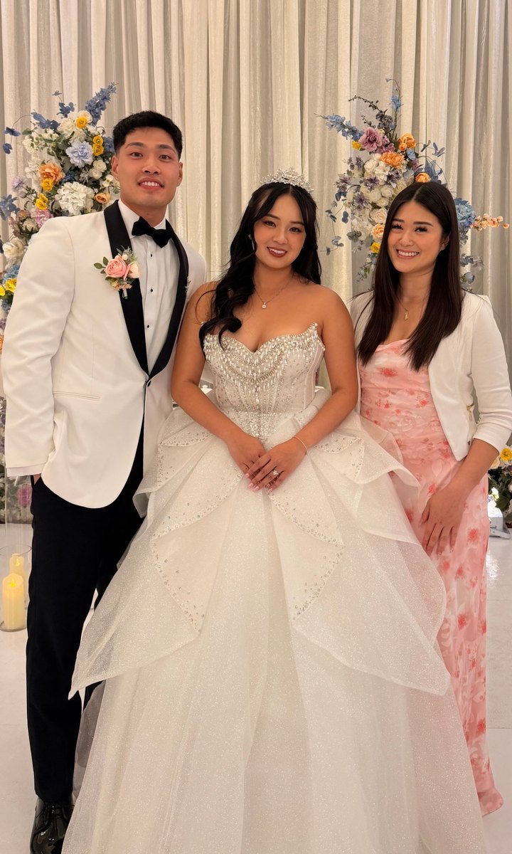 Lisa Nguyen with a bride and groom at their wedding reception